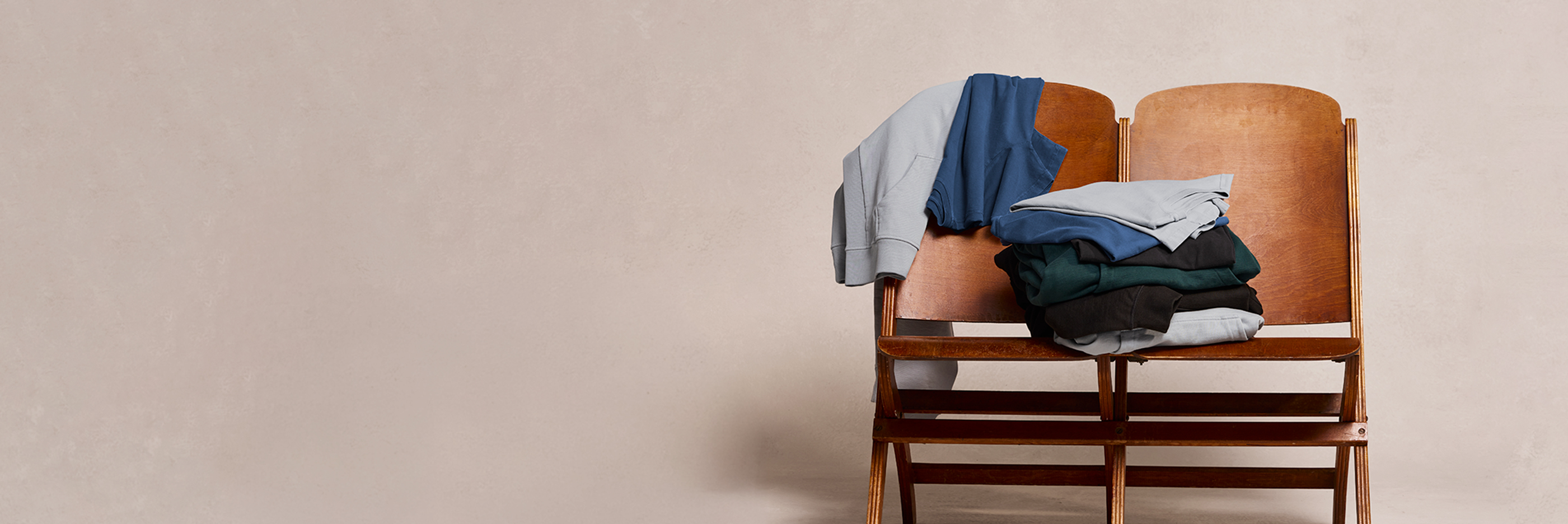 Two chairs with clothes on a beige background