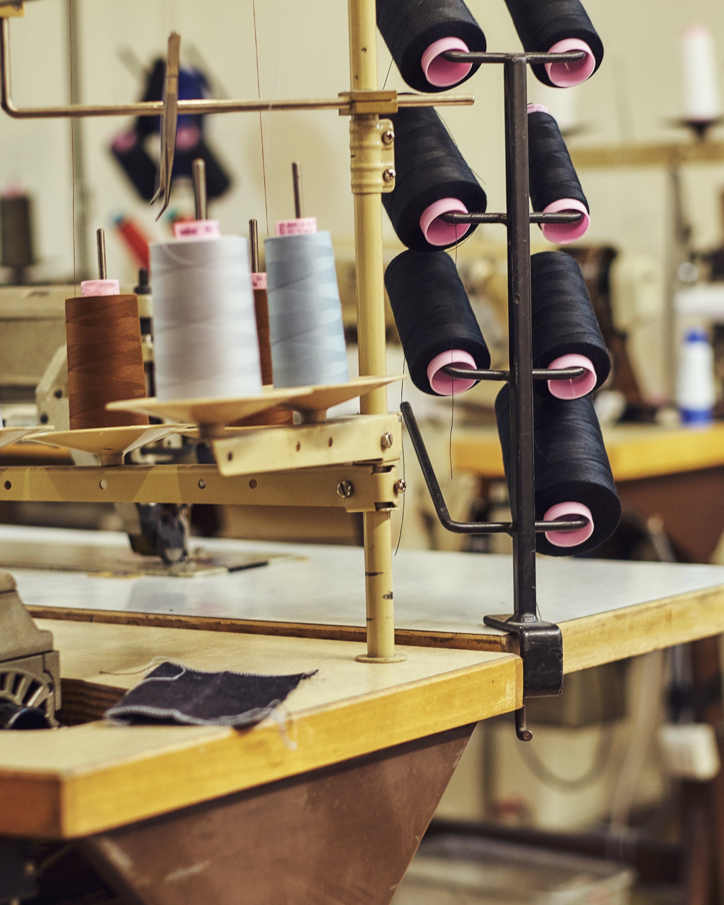 Sewing machine with spools of thread in a workshop setting